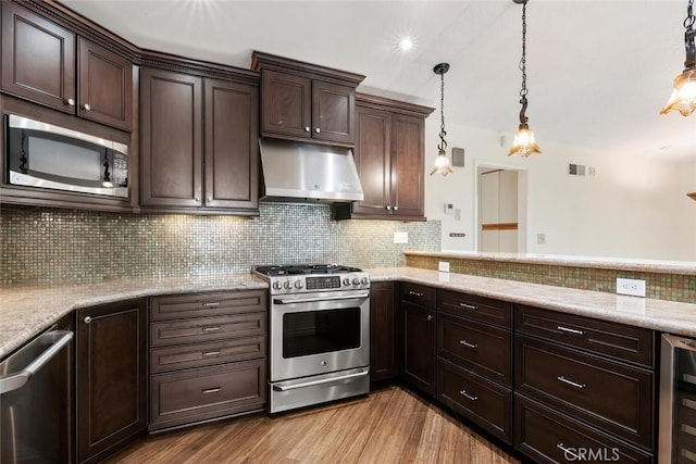 29121 Thousand Oaks Blvd Unit C, Agoura Hills, CA 91301 - kitchen with stainless steel appliances, under cabinet range hood, dark brown cabinets, light wood-style flooring, and recessed lighting