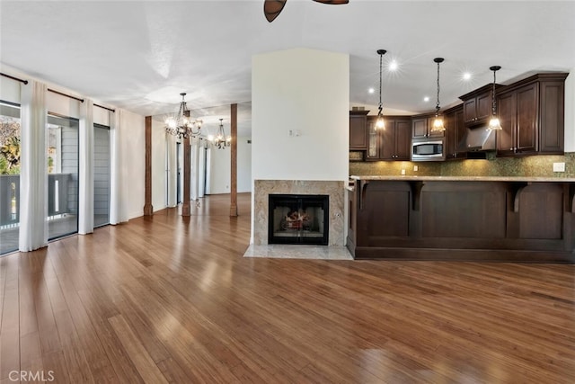 29121 Thousand Oaks Blvd Unit C, Agoura Hills, CA 91301 - kitchen featuring stainless steel microwave, dark brown cabinets, a chandelier, wood finished floors, and tasteful backsplash