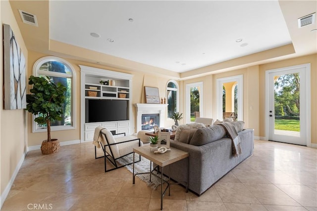 living room featuring built in shelves and light tile patterned floors