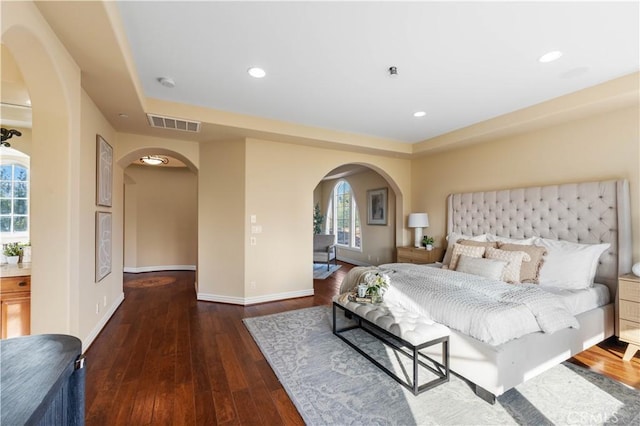 bedroom featuring a raised ceiling and dark wood-type flooring