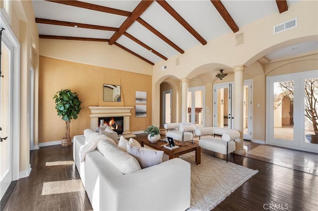 living room featuring beam ceiling, ornate columns, french doors, dark wood-type flooring, and high vaulted ceiling