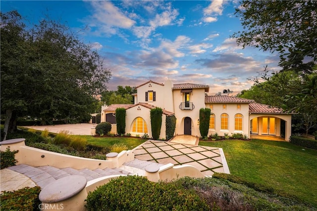 mediterranean / spanish home featuring a balcony and a lawn