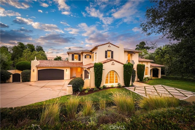 mediterranean / spanish home with a lawn and a garage