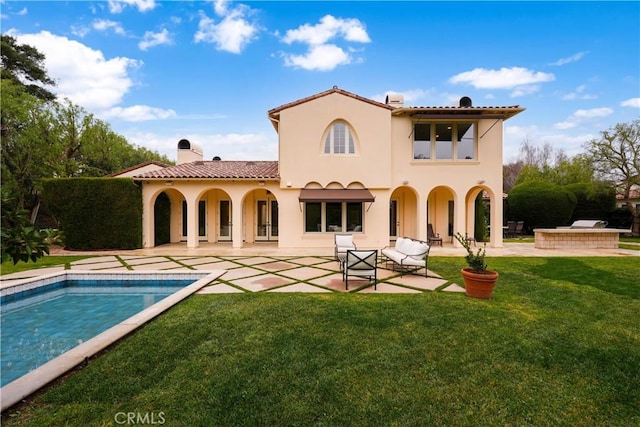 back of house featuring a lawn and a patio area