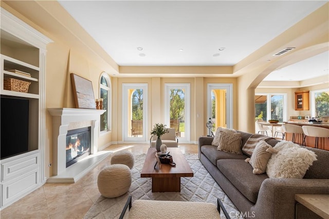 living room featuring built in shelves and light tile patterned floors