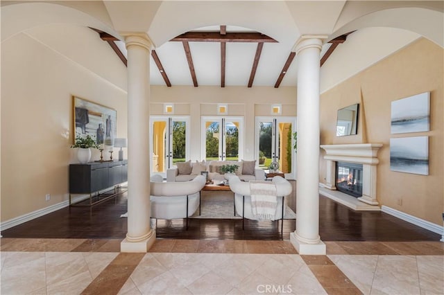 living room with beamed ceiling, ornate columns, and french doors