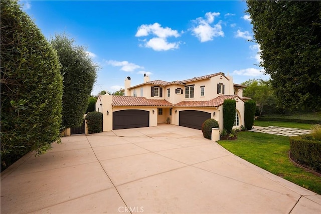 mediterranean / spanish-style home featuring a front yard and a garage