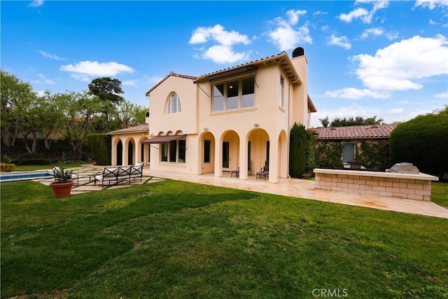 back of house featuring a lawn and a patio