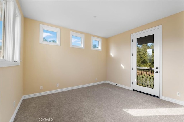 unfurnished room with plenty of natural light and light carpet