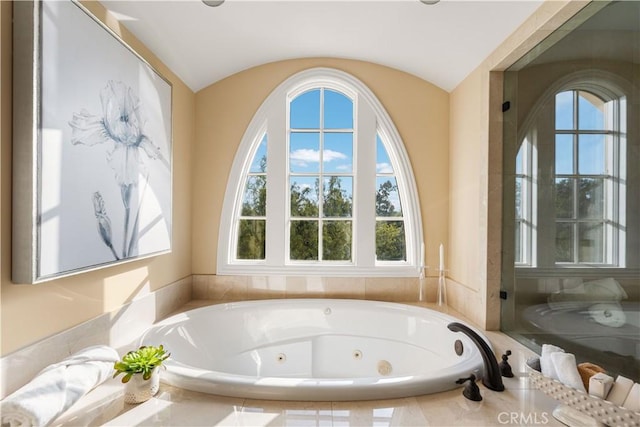 bathroom with tiled bath and vaulted ceiling