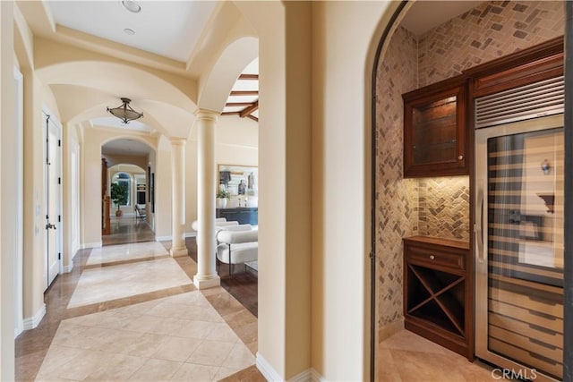 interior space featuring wine cooler and decorative columns