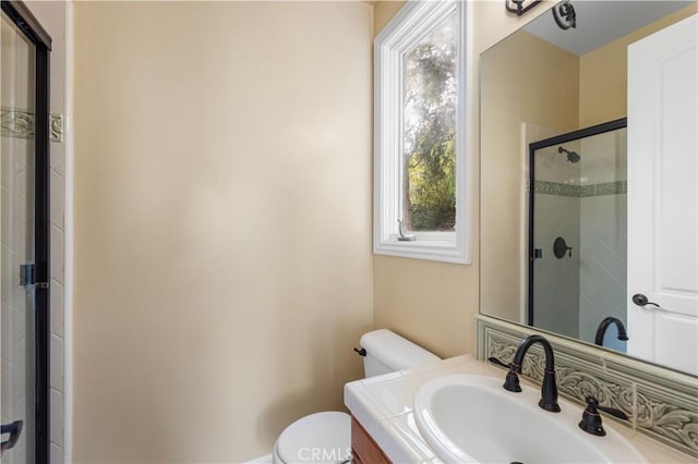 bathroom with toilet, an enclosed shower, and vanity