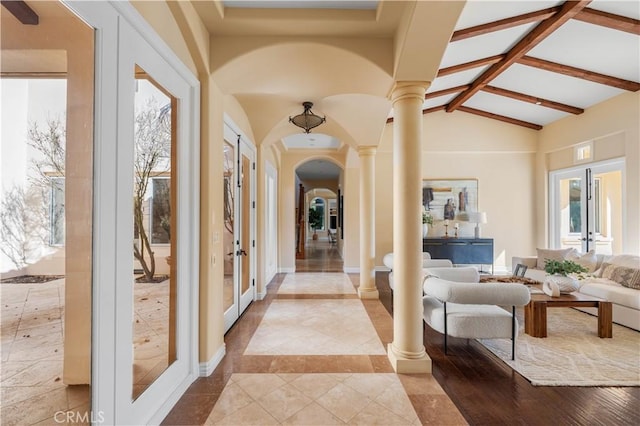 interior space featuring french doors, vaulted ceiling with beams, and ornate columns