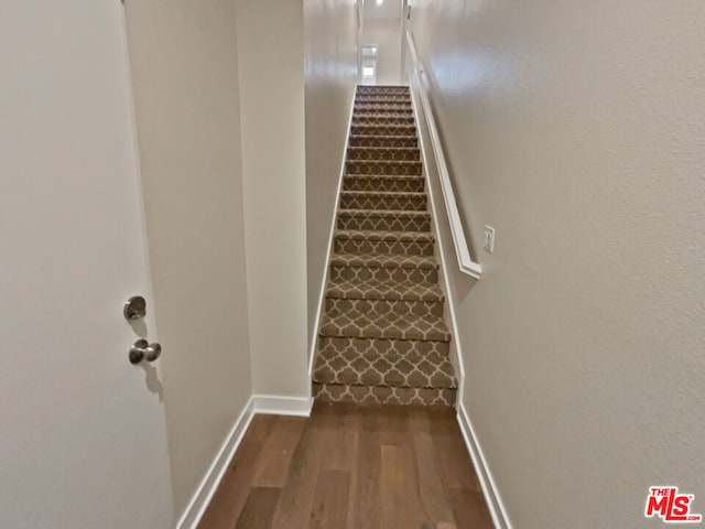 stairs featuring hardwood / wood-style floors