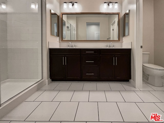 bathroom featuring tile patterned flooring, a tile shower, vanity, and toilet