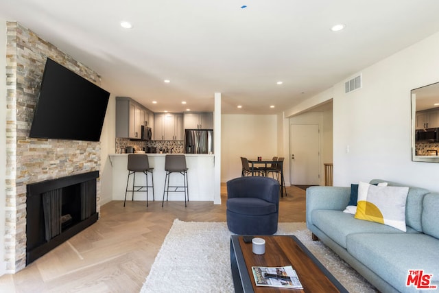 living room with a fireplace and light parquet floors