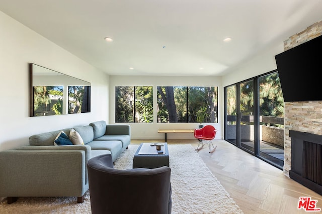 living room with a stone fireplace and light parquet floors