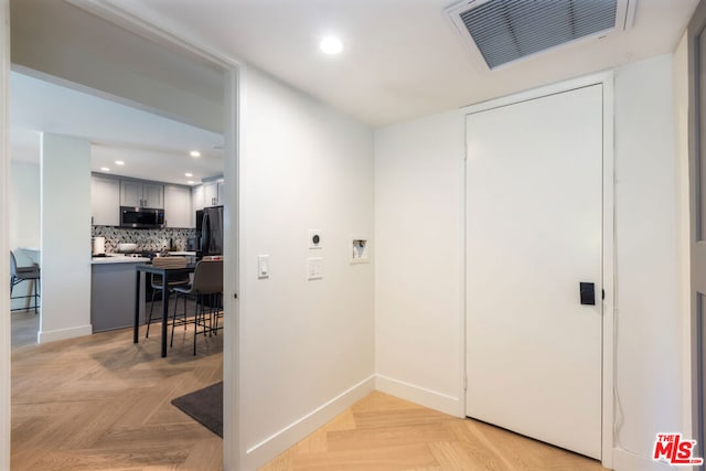 laundry room with light parquet floors and washer hookup