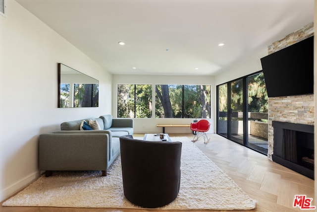 living room with a stone fireplace and light parquet floors