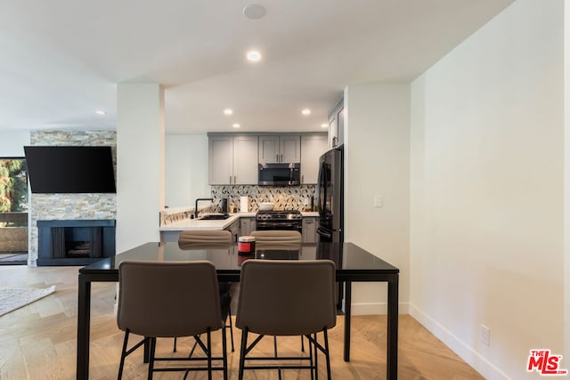 dining area featuring a stone fireplace and sink