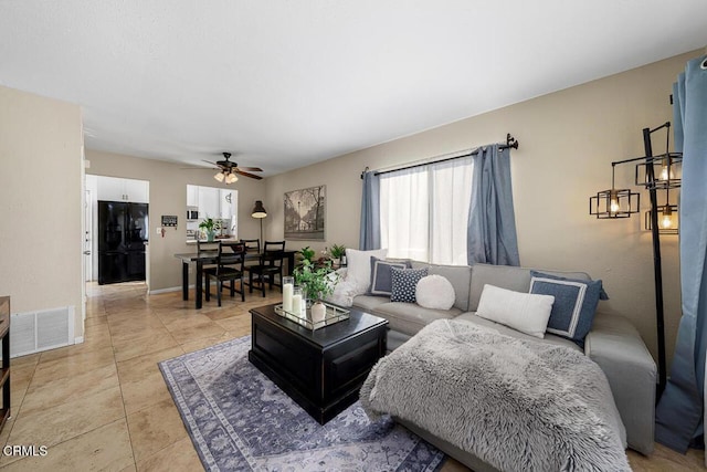 living room with ceiling fan and light tile patterned flooring