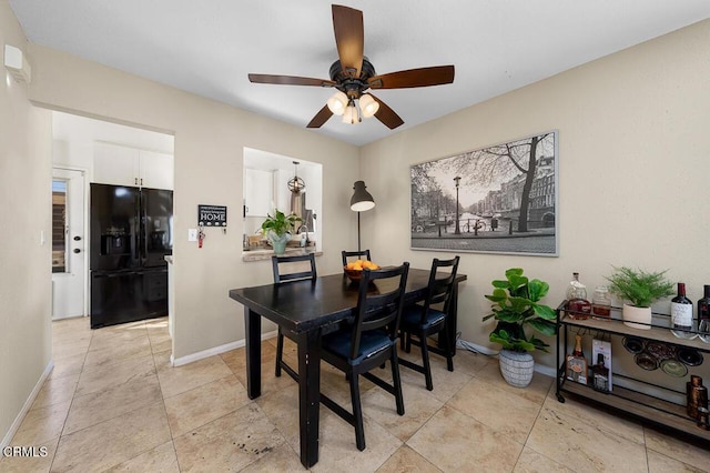 dining room with light tile patterned floors, baseboards, and ceiling fan