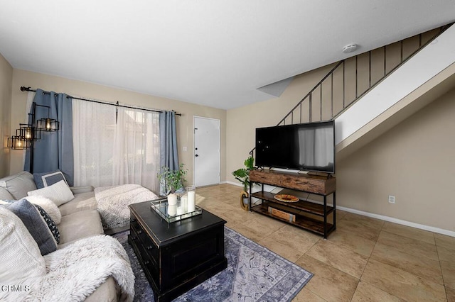 living area featuring light tile patterned floors and baseboards