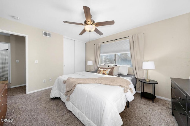 carpeted bedroom featuring a ceiling fan, baseboards, visible vents, and a closet