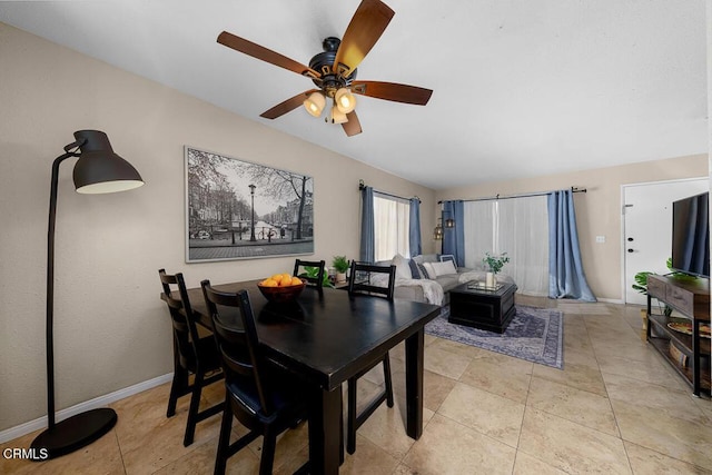 dining room featuring light tile patterned flooring, a ceiling fan, and baseboards