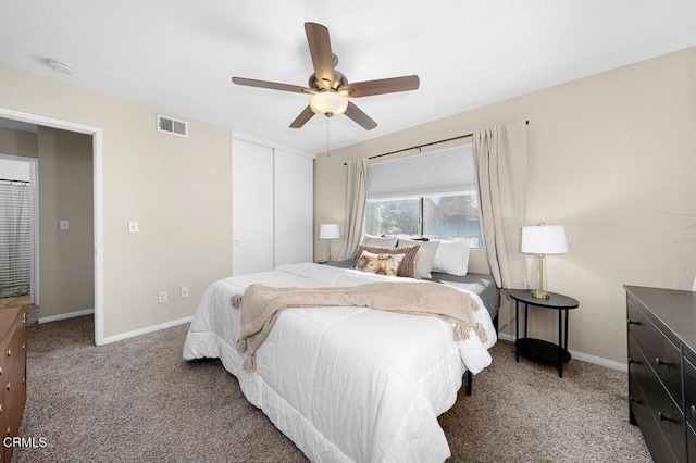 bedroom with a closet, carpet flooring, visible vents, baseboards, and ceiling fan