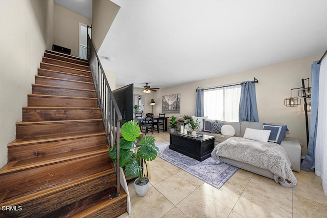 living room featuring ceiling fan, stairway, and light tile patterned floors