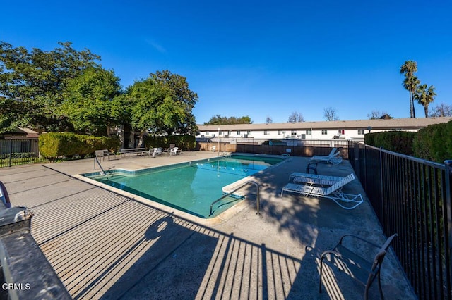 pool with a patio and fence