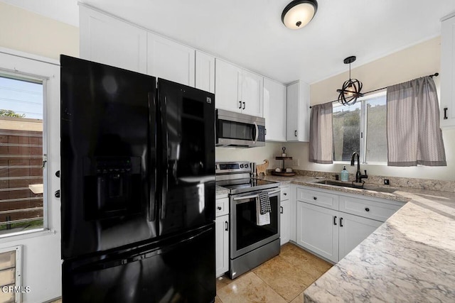 kitchen with hanging light fixtures, white cabinetry, a sink, and stainless steel appliances