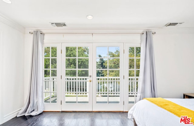 bedroom with dark hardwood / wood-style flooring, access to exterior, and crown molding