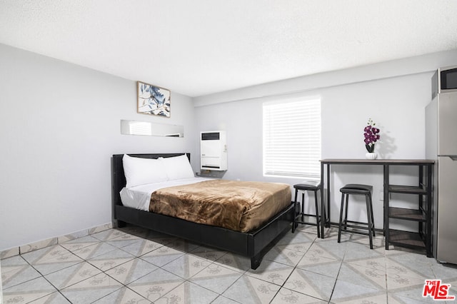 bedroom featuring stainless steel fridge