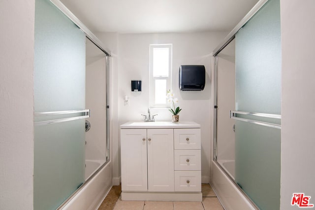 bathroom with shower / bath combination with glass door, vanity, and tile patterned flooring