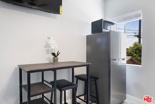 kitchen featuring stainless steel fridge and a kitchen breakfast bar