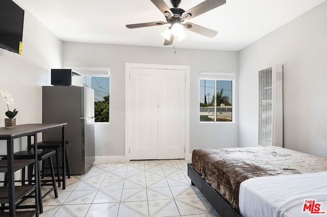 bedroom featuring ceiling fan, stainless steel fridge, and a closet