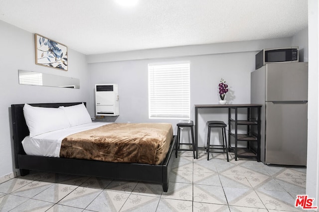 bedroom featuring stainless steel fridge