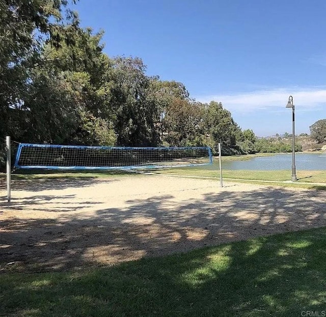 view of home's community featuring volleyball court and a water view