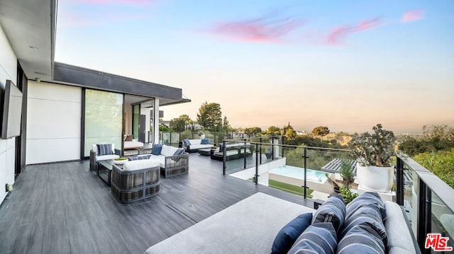 deck at dusk featuring an outdoor living space