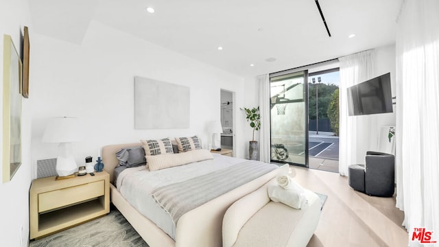 bedroom with a wall of windows, access to exterior, and light hardwood / wood-style floors