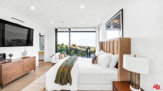 bedroom featuring floor to ceiling windows and hardwood / wood-style flooring