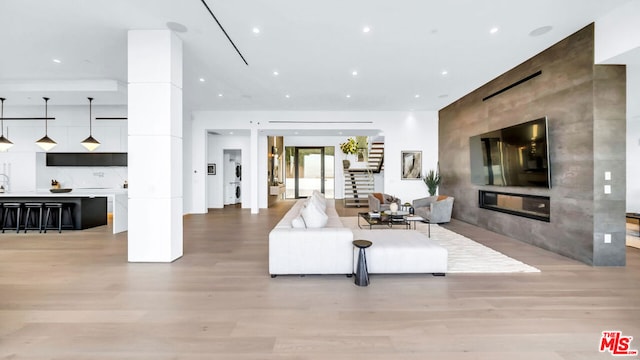 living room featuring a large fireplace and light hardwood / wood-style flooring