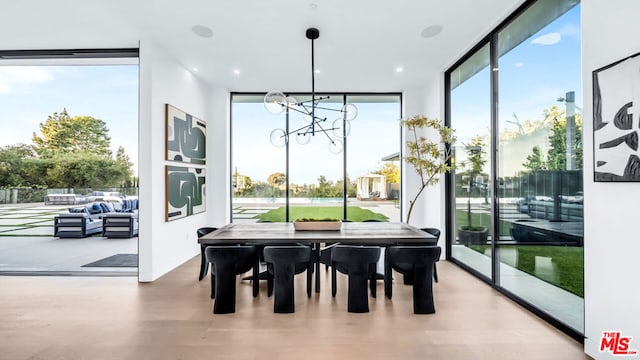 dining room featuring an inviting chandelier, floor to ceiling windows, and hardwood / wood-style flooring