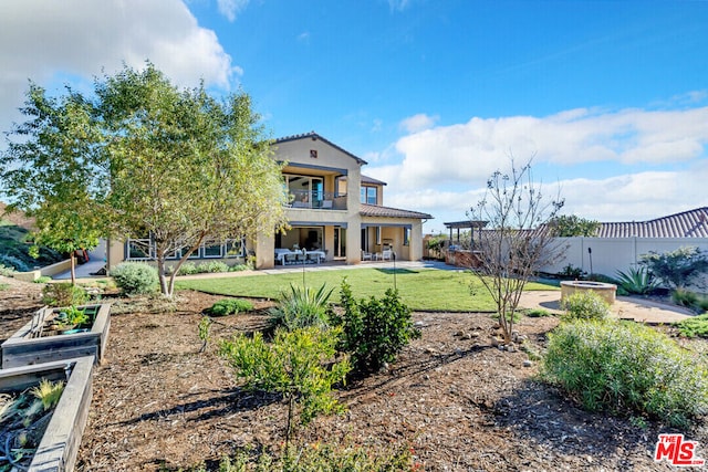 back of house featuring a patio area, a balcony, and a yard