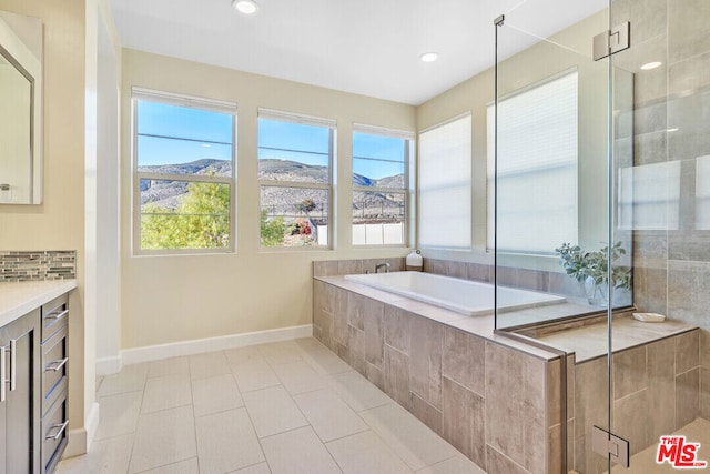 bathroom featuring a mountain view, vanity, tile patterned flooring, independent shower and bath, and tasteful backsplash