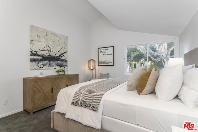 bedroom with dark carpet and vaulted ceiling