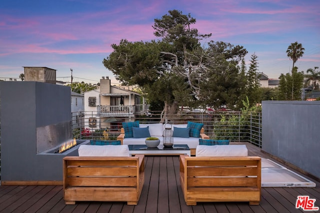 deck at dusk with outdoor lounge area