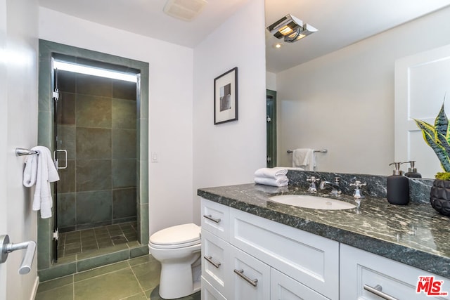 bathroom featuring tile patterned floors, vanity, toilet, and an enclosed shower